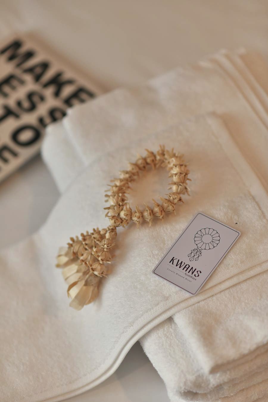 Woven garland and KWANS card on folded white towels