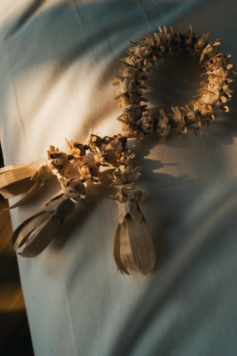 A woven blessing garland laid on white linen