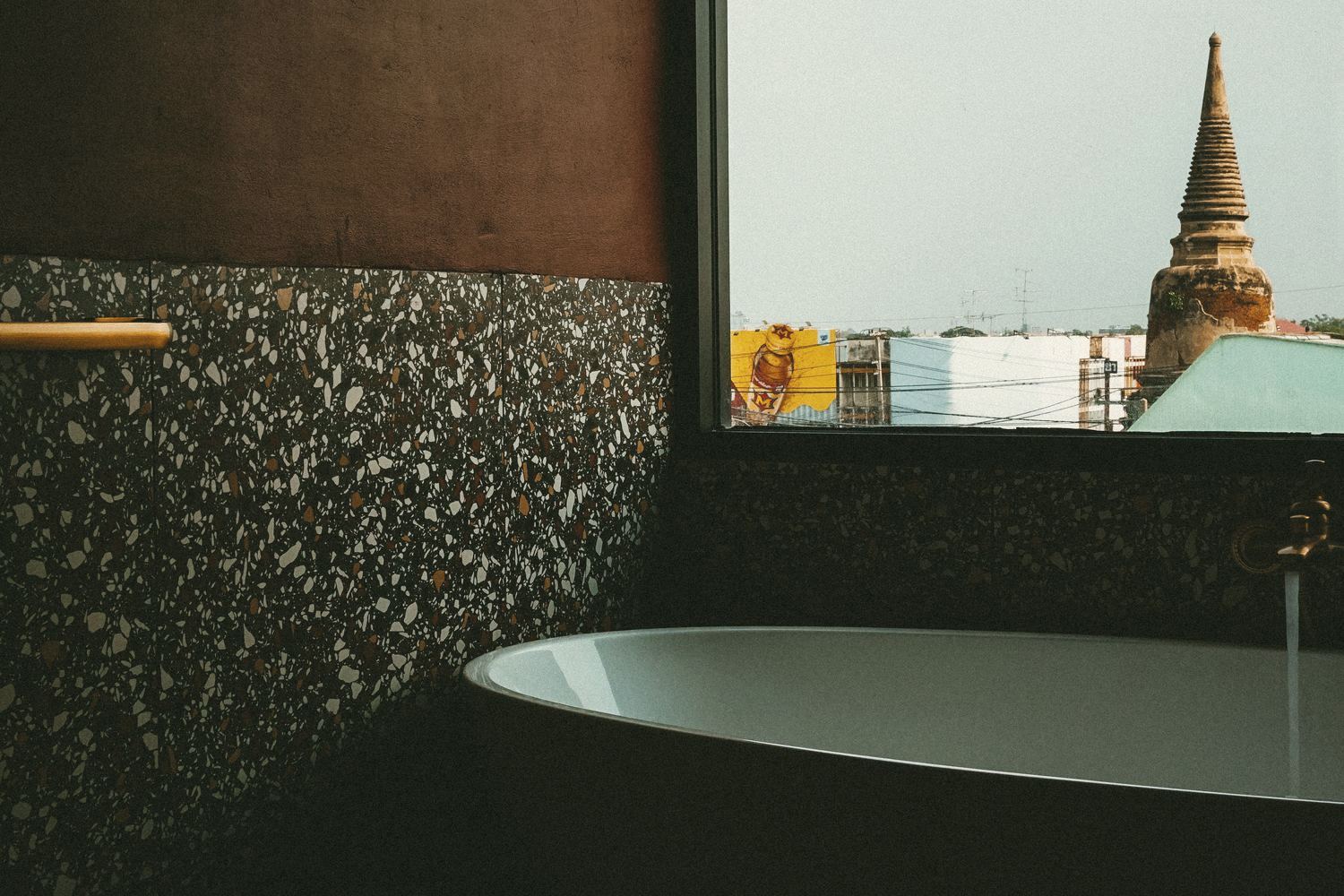 KWANS Suite bathtub on terrazzo with the chedi framed in the window