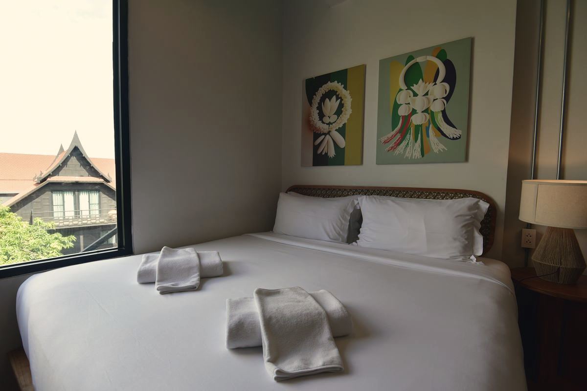 Holy Superior bed beside a window onto a traditional Thai roof