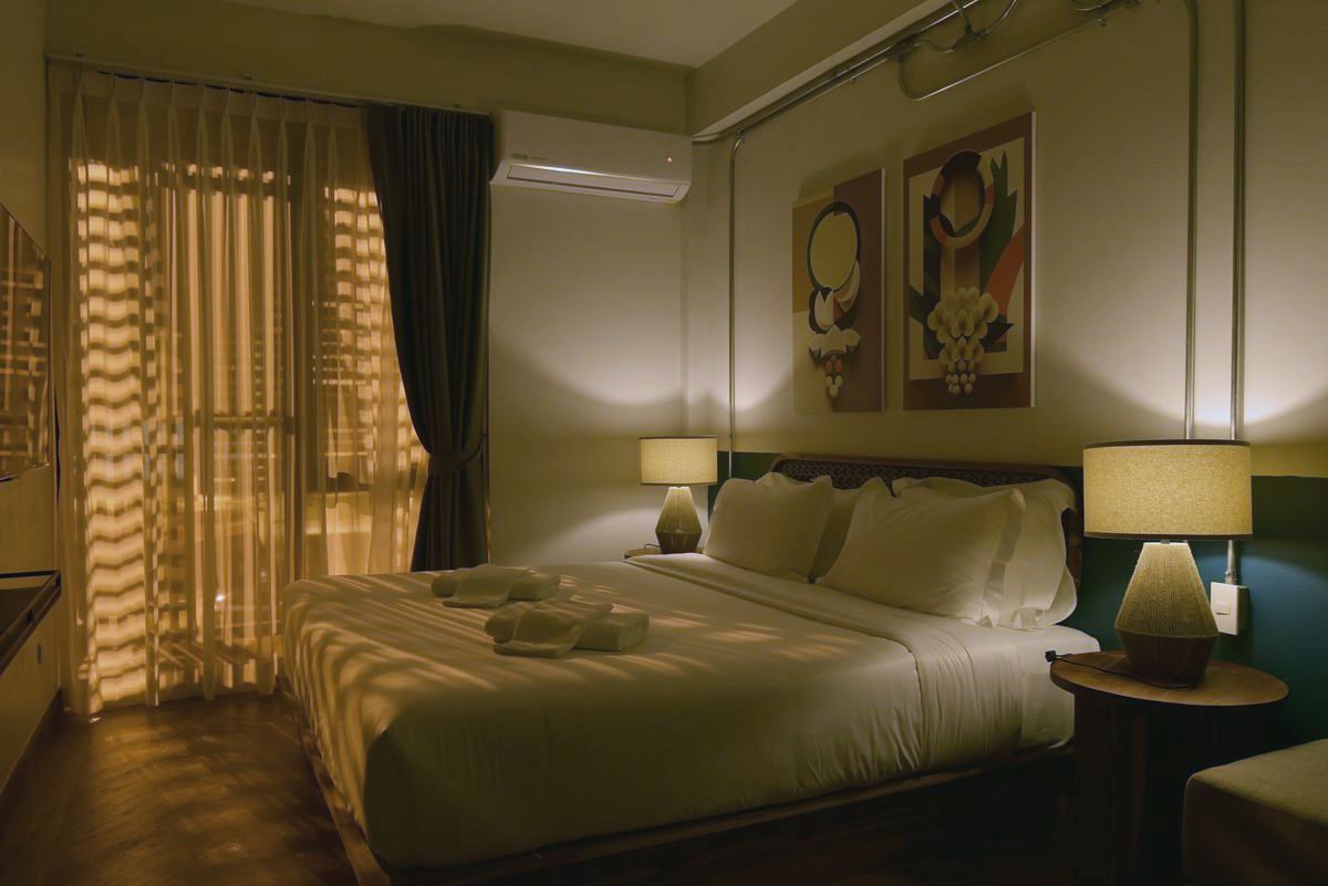 Holy Deluxe at night with warm light falling through the teak slats